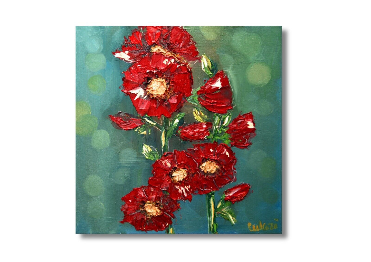 a vase of red flowers sitting on a table 